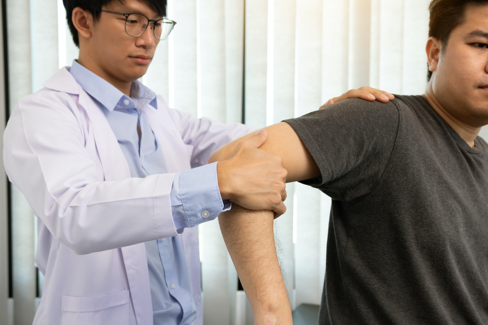 Physical therapists press to the patient shoulder check for pain.