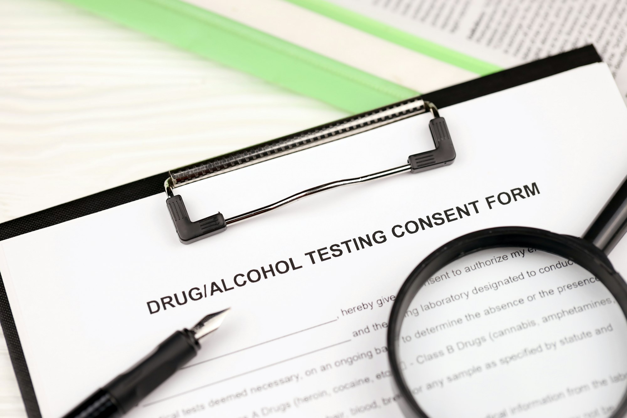 Drug and alcohol testing consent form on A4 tablet lies on office table with pen