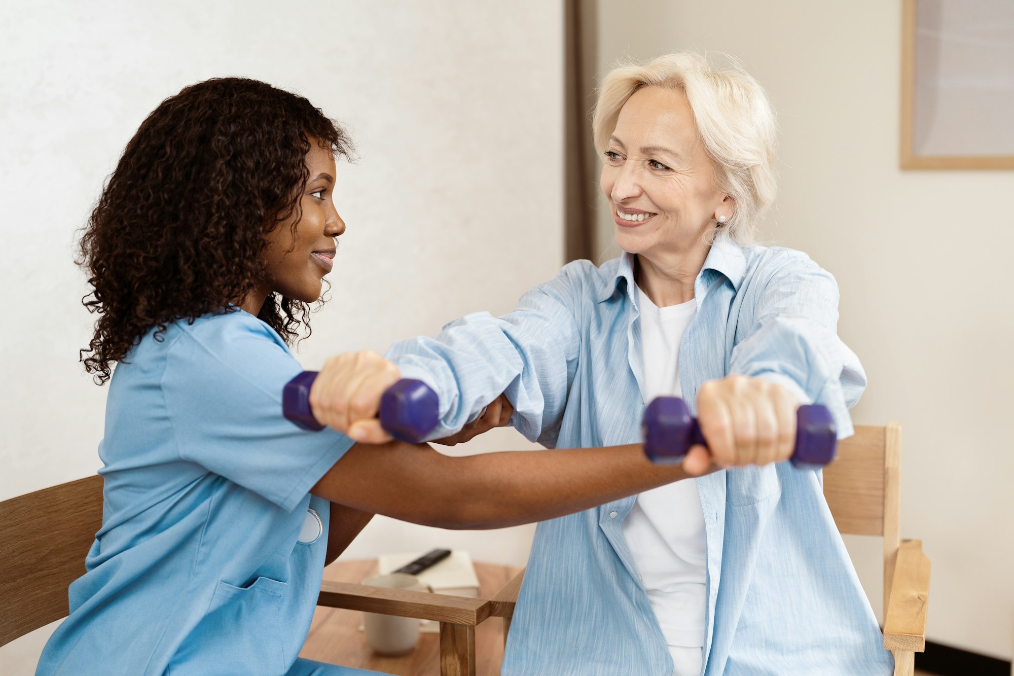 Healthcare Worker Assisting Senior Woman in Physical Therapy Exercise